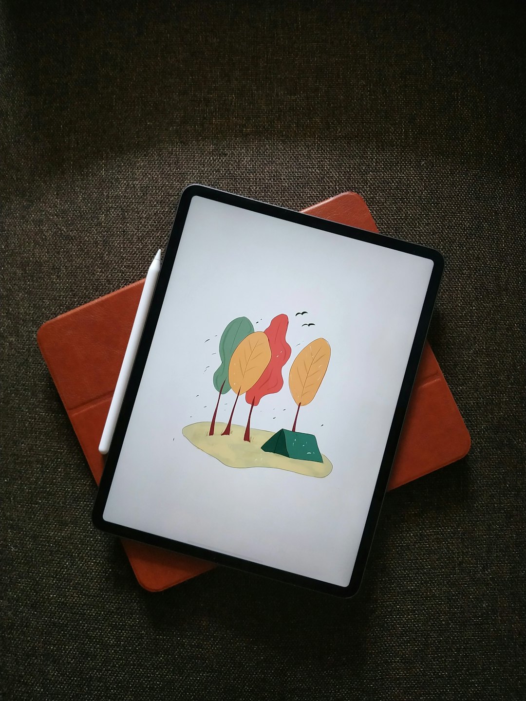 Tableta mostrando arte digital con lápiz en estuche abierto.